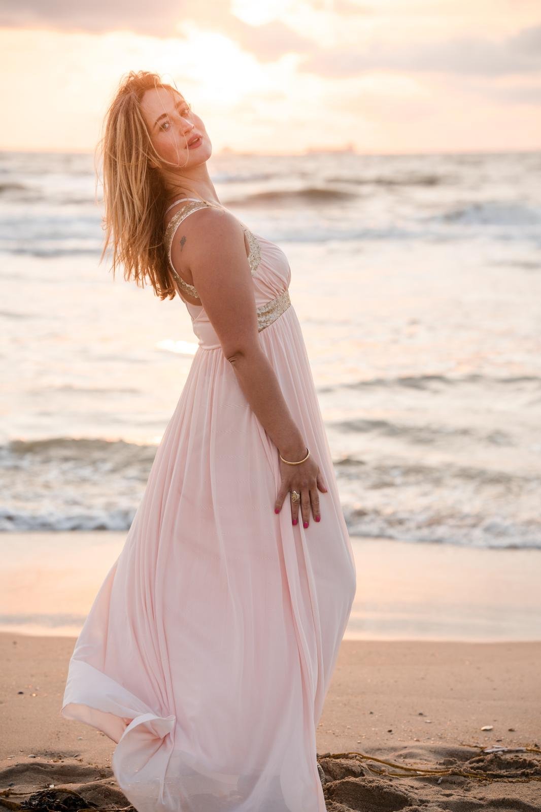 Manja van Ham in roze jurk op het strand